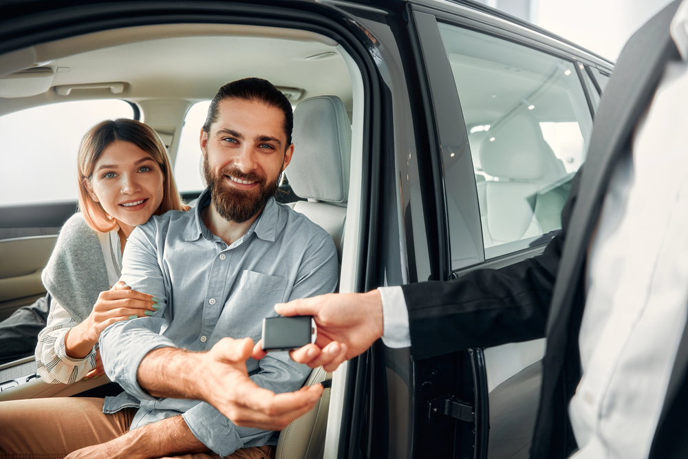 Cliente feliz recibiendo las llaves de su nuevo auto